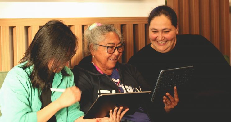 three women viewing ipads and smiling